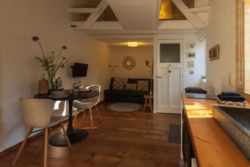een keuken en woonkamer met een tafel en stoelen bij Authentiek vakantiehuisje in Terneuzen