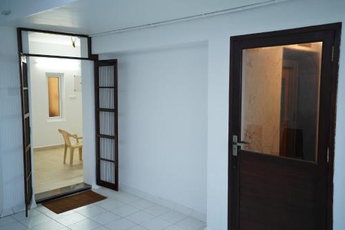 an open door leading to a room with a chair at SAARA INN in Pondicherry