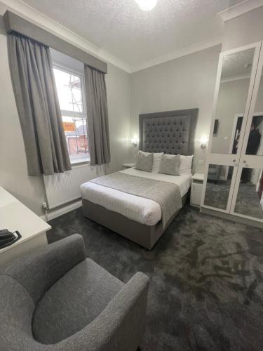 a bedroom with a bed and a chair and a couch at Park House Hotel in Blackpool
