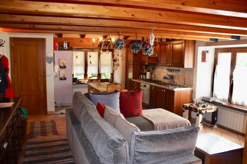 uma sala de estar com um sofá e uma cozinha em Appartamenti vista Monte Bianco Courmayeur-Entrèves em Entrèves