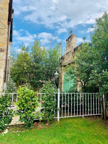 a white fence in front of an old building at Posada La Torre de La Quintana in Liendo