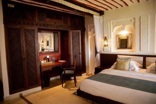 a bedroom with a bed and a desk in it at Serena Beach Resort & Spa in Mombasa