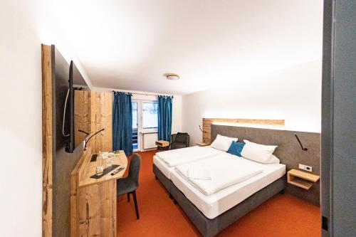 um quarto com uma cama, uma secretária e uma cama em Am Ochsenkopf em Bischofsgrün