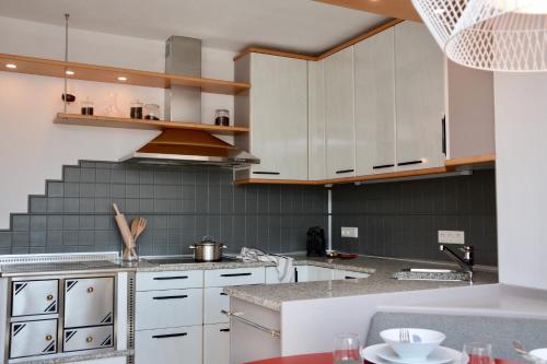 a kitchen with white cabinets and a counter top at Freien Living Angerberg in Angerberg