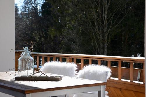 a table on a porch with two chairs and a vase at Freien Living Angerberg in Angerberg