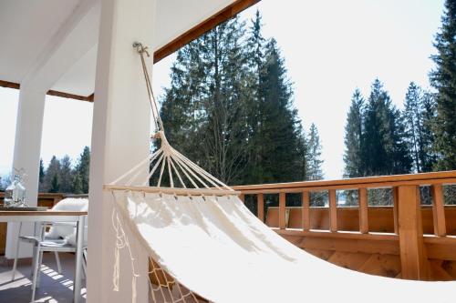 a hammock on a deck with trees in the background at Freien Living Angerberg in Angerberg