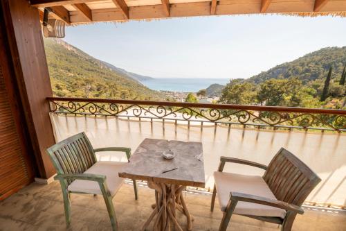 a table and chairs on a balcony with a view at Ölüdeniz Loft - Adults Only in Oludeniz