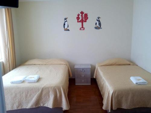 two beds in a small room with two beds sidx sidx sidx at Antares Paracas in Paracas