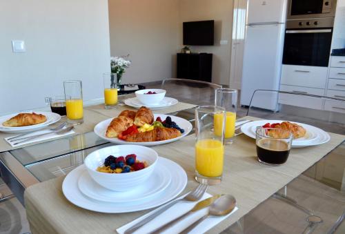 a table with plates of food and bowls of fruit at Villa ELTAEL - Rita Apartment - Warm Pool from April 2026 in Manta Rota