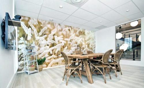 a dining room with a wooden table and chairs at Coloft in Lesquin