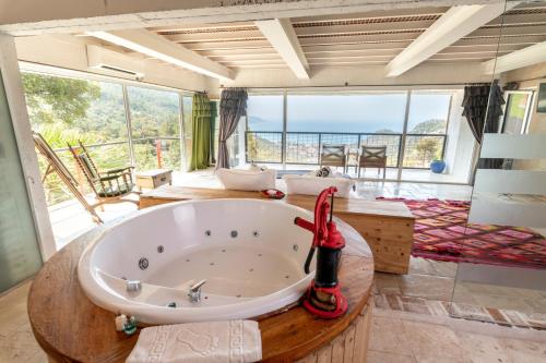 a large bathroom with a large tub with a view of the ocean at Ölüdeniz Loft - Adults Only in Oludeniz