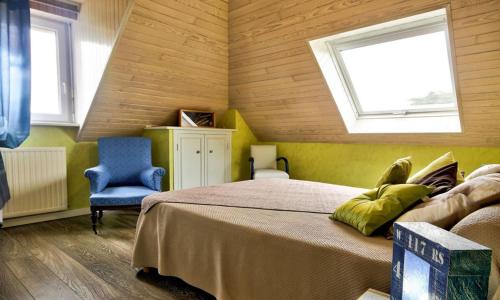ein Schlafzimmer mit einem Bett und einem blauen Stuhl in der Unterkunft Ty an Aod in Kerlaz