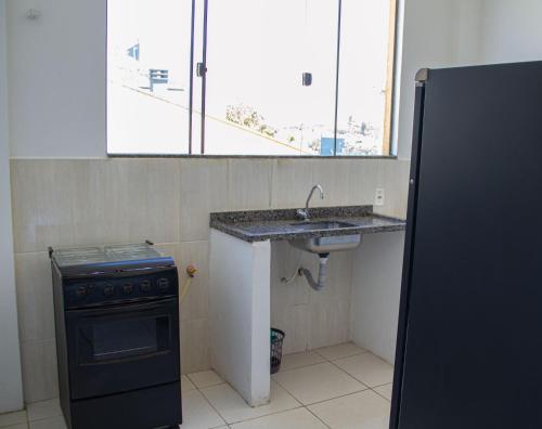 a small kitchen with a sink and a stove at Pousada Estrela Dourada in Guaratuba