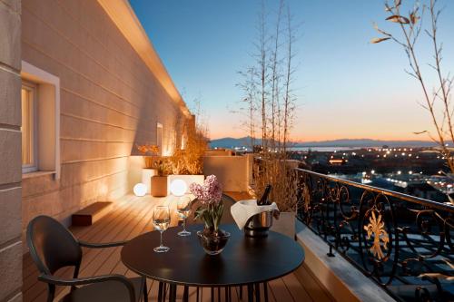 a balcony with a table and wine glasses on it at Grand Hotel Palace in Thessaloniki