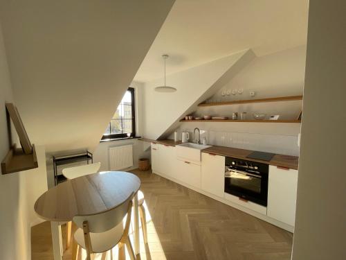 a kitchen with white cabinets and a table in it at APARTAMENT OVOC 2.0 in Chodzież