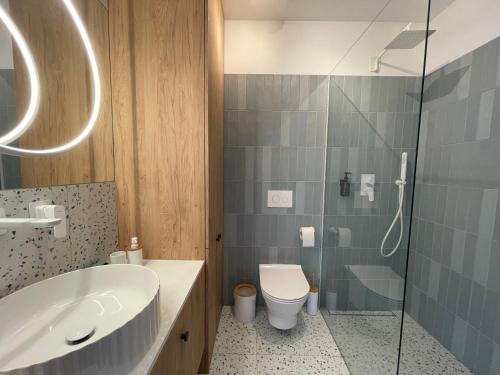 a bathroom with a sink and a toilet and a shower at APARTAMENT OVOC 2.0 in Chodzież