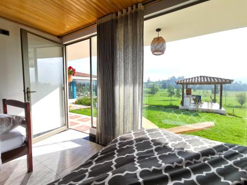 a bedroom with a bed and a large window at Lujosa Casa Quinta en Naturaleza Andina in Iza