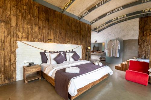 a bedroom with a large bed with a wooden wall at Ölüdeniz Loft - Adults Only in Oludeniz