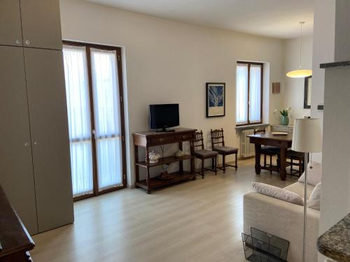 - un salon avec un canapé, une télévision et une table dans l'établissement Barolo Apartments, à Barolo