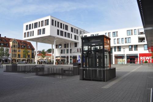 a building with a phone booth in the middle of a street at ARKADEN Hotel Kelkheim in Kelkheim
