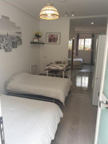 a room with three beds in a room with a mirror at Bonito Apto Cinco Torres Plaza Castilla in Madrid