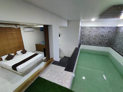 a bedroom with a bed and a swimming pool at Hotel Jurkis, Kolhapur in Kolhapur