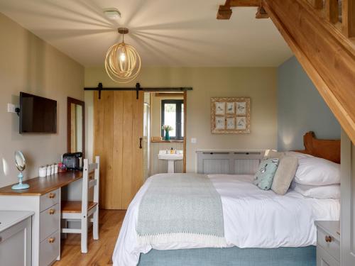 a bedroom with a bed and a desk and a sink at The Plough Inn in Stalisfield