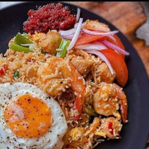a plate of fried rice with eggs and vegetables at Goyambokka Guesthouse in Tangalle