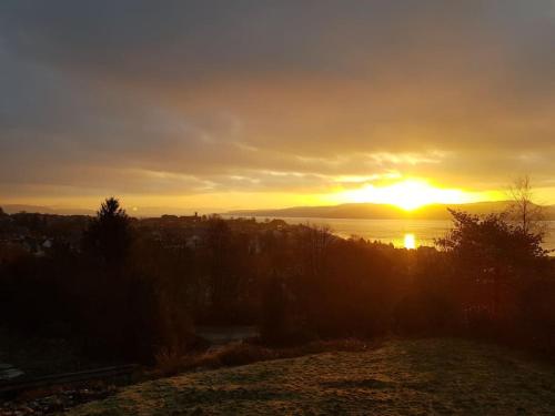 a sunset over a body of water with the sun setting at The Annex, Kilbride Farmhouse in Dunoon