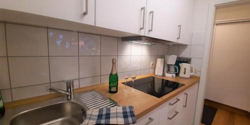una cocina con fregadero y una botella de vino en Appartement Bergdorf Steibis, en Steibis