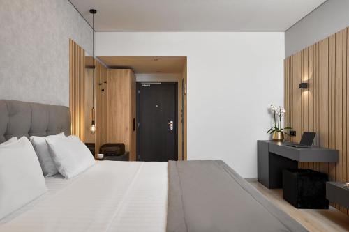 a bedroom with a large white bed and a desk at Grand Hotel Palace in Thessaloniki