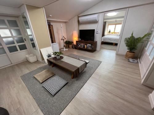 ein Wohnzimmer mit einem Sofa und einem Tisch in der Unterkunft Jeju Time in Jeju-do
