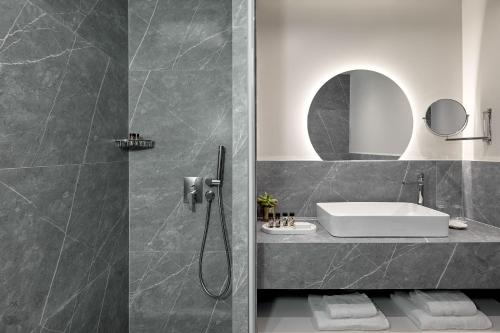a bathroom with a sink and a shower at Grand Hotel Palace in Thessaloniki