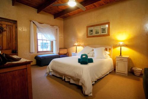 Un dormitorio con una cama con una maleta. en Finchley Farm Cottages en Willowmore