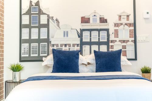 1 dormitorio con 1 cama con almohadas azules y blancas en INITIAL - Suite NOUVEAU MONDE - Centre-ville de Québec, en Quebec