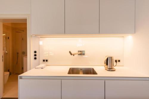 uma cozinha com um lavatório e armários brancos em Haus-El-Mar-Wohnung-H-Beachlove em Grossenbrode