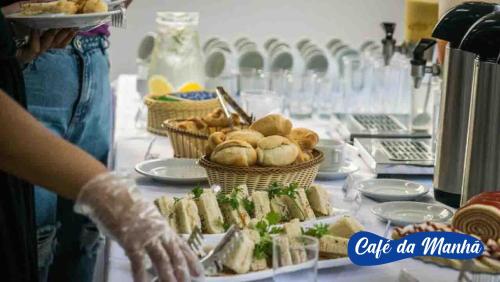 a person reaching for a table with baskets of food at Asenza Beach Resort All Inclusive in Pitimbu