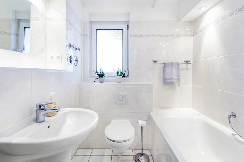 ein weißes Badezimmer mit einem Waschbecken, einem WC und einer Badewanne in der Unterkunft Ferienwohnung Berlin in Berlin