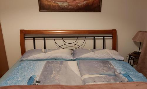 a bed with a wooden headboard and two pillows at Traumoase in Timmendorfer Strand in Timmendorfer Strand