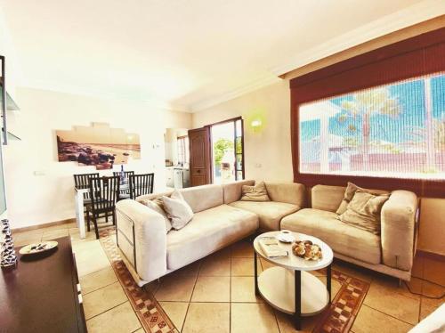 ein Wohnzimmer mit einem Sofa und einem Tisch in der Unterkunft Villa Ágatha, vacaciones en familia en Lanzarote in Playa Blanca