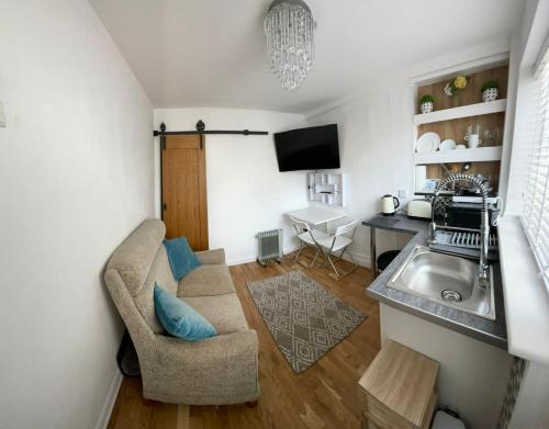 a small living room with a sink and a couch at Beach retreat in Prestatyn