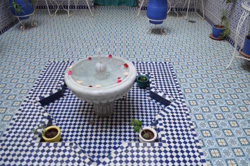 
a white toilet sitting on top of a tile floor at Riad Hôtel Essaouira in Marrakesh
