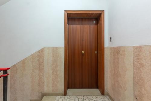 a wooden door in a room with stairs at a 500 mt dalla Certosa Apartment in Bologna
