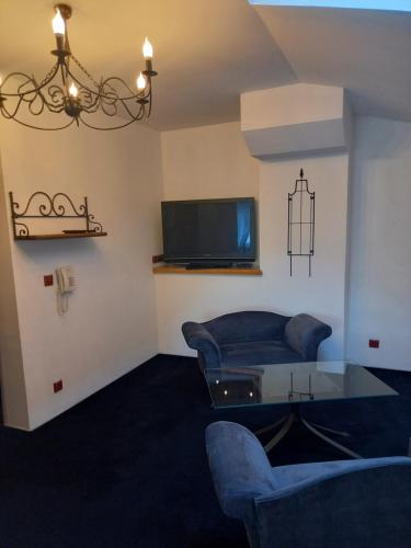 Penzion starojicka pizza في Starý Jičín: غرفة معيشة مع أريكة وتلفزيون