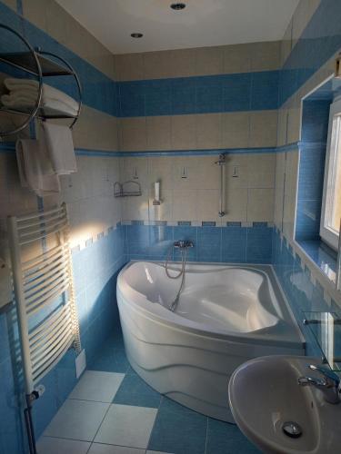 Penzion starojicka pizza في Starý Jičín: حمام مع حوض استحمام أبيض ومغسلة