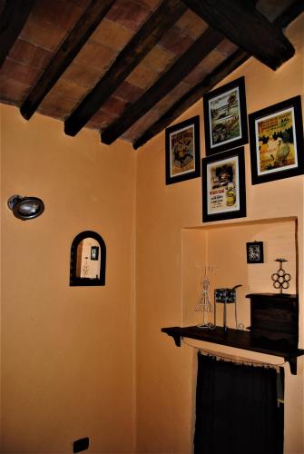 a living room with a fireplace and pictures on the wall at NIDO SCANSANESE in Scansano