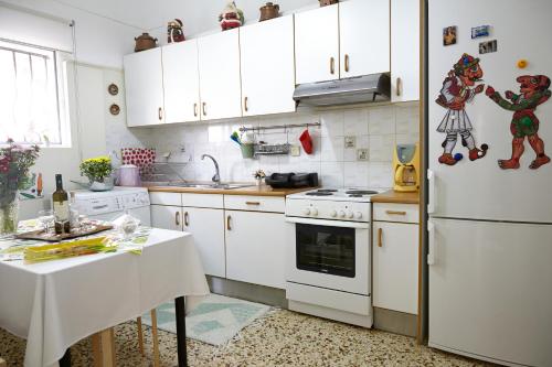 een keuken met witte kasten en een witte koelkast bij House with Yard by the Hill in Athene