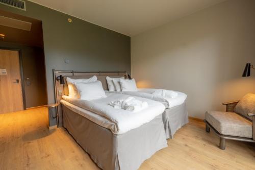 two beds in a room with white sheets at Lily Country Club in Klofta