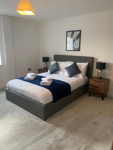 a large bed in a bedroom with two night stands and two lamps at Icona - Stylish 2 bed apartment in York