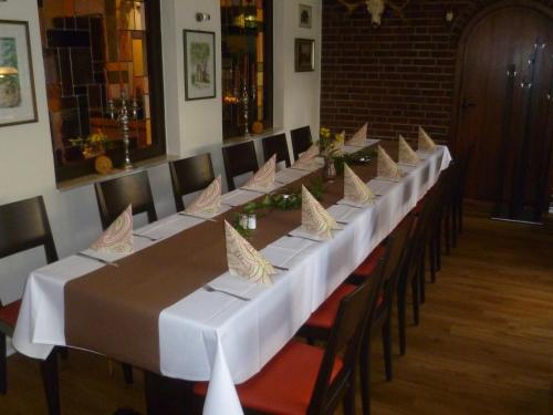 a long long table with white tables and chairs at Hotel Grüner Jäger in Travemünde